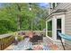 Cozy back deck features an outdoor seating area, wooden benches, a colorful rug, and ambient string lights at 10090 Feather Sound Ct, Alpharetta, GA 30022