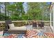 Relaxing outdoor deck with lounge chair, seating area, wooden benches, colorful rug, and ambient string lights at 10090 Feather Sound Ct, Alpharetta, GA 30022