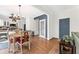 Dining area with wood floors next to the kitchen, featuring a modern light fixture and access to the hall at 10090 Feather Sound Ct, Alpharetta, GA 30022