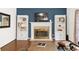 Living room fireplace featuring a mantle and built-in bookshelves on either side with hardwood flooring at 10090 Feather Sound Ct, Alpharetta, GA 30022