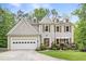 Charming two-story home with a manicured lawn, front porch, and attached garage, perfect for suburban living at 10090 Feather Sound Ct, Alpharetta, GA 30022