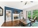 Cozy living room featuring a fireplace, built-in bookshelves, hardwood floors, and large windows at 10090 Feather Sound Ct, Alpharetta, GA 30022