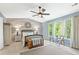 Spacious main bedroom with wood accent wall, ceiling fan, and views of greenery at 10090 Feather Sound Ct, Alpharetta, GA 30022