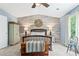 Spacious main bedroom with wood accent wall, ceiling fan, and views of greenery at 10090 Feather Sound Ct, Alpharetta, GA 30022
