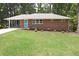 Charming single-story brick home featuring a manicured front lawn and a bright blue front door at 1140 Starline Se Dr, Smyrna, GA 30080