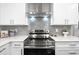 Close up of the kitchen's stainless steel stove, hood and the gray tile backsplash at 1140 Starline Se Dr, Smyrna, GA 30080