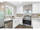 Modern kitchen featuring stainless steel appliances, white cabinets, and a stylish backsplash at 1140 Starline Se Dr, Smyrna, GA 30080