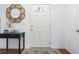 Inviting entryway featuring a white door with glass detail, dark wood floors, and a decorative mirror at 1560 Avalon Creek Rd, Sugar Hill, GA 30518