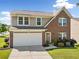 Charming two-story home showcasing a brick and siding facade, well-manicured lawn, and a two-car garage at 1560 Avalon Creek Rd, Sugar Hill, GA 30518