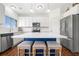 Stylish kitchen showcasing a blue island with bar stools, white cabinets, and stainless steel appliances at 1560 Avalon Creek Rd, Sugar Hill, GA 30518
