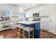 Well-equipped kitchen featuring white cabinets, a blue island with seating, and modern stainless steel appliances at 1560 Avalon Creek Rd, Sugar Hill, GA 30518