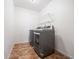 Modern laundry room equipped with a front-load washer, dryer and storage shelves at 1560 Avalon Creek Rd, Sugar Hill, GA 30518