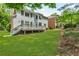 Lush, green backyard and landscaping, with multi-level deck and tree line in the distance at 5303 Davenport Mnr, Cumming, GA 30041