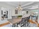 Traditional dining room with a large table, modern chandelier, and hardwood floors at 5303 Davenport Mnr, Cumming, GA 30041