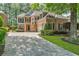 Elegant two-story home with brick and stone facade, complemented by a lush green lawn and mature trees at 5303 Davenport Mnr, Cumming, GA 30041