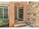 Inviting front entrance featuring brick and stone accents, a wreath-adorned door, and a charming pendant light at 5303 Davenport Mnr, Cumming, GA 30041