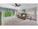 Spacious living room with a large window view, cozy sofa, and modern ceiling fan at 5303 Davenport Mnr, Cumming, GA 30041