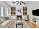 Inviting living room with a fireplace, built-in shelves, hardwood floors, and a comfortable seating arrangement at 5303 Davenport Mnr, Cumming, GA 30041