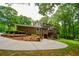 Expansive backyard with a two-story deck, mature trees, well-maintained landscaping, and a large concrete driveway at 110 Sandy Ridge Trl, Fayetteville, GA 30214