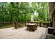 Back deck featuring outdoor dining furniture and scenic views of surrounding trees at 110 Sandy Ridge Trl, Fayetteville, GA 30214
