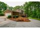 Exterior view of a brick house with a deck, two-car garage, and lush landscaping at 110 Sandy Ridge Trl, Fayetteville, GA 30214