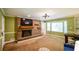 Cozy living room featuring a brick fireplace and mantle with a bay window and modern light fixture at 110 Sandy Ridge Trl, Fayetteville, GA 30214