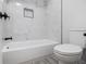 Bathroom features a new white tub with white marble style tile and modern fixtures at 1225 Church St # A, Decatur, GA 30030