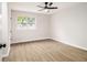 This bedroom features wood-look flooring, a modern ceiling fan, and ample natural light from the large window at 1225 Church St # A, Decatur, GA 30030