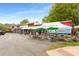 Outdoor patio with seating outside Paolino's restaurant, featuring green umbrellas and tents for shade at 1585 San Gabriel Ave, Decatur, GA 30032
