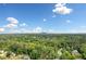 Scenic aerial view of a lush, green neighborhood under a bright blue sky with scattered clouds at 2144 Lamplight Dr, Marietta, GA 30062