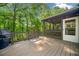 View of the back deck, grill, screened-in porch with lighting, and wooded view at 2144 Lamplight Dr, Marietta, GA 30062