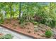 Lovely two-story home nestled on a landscaped hillside with lush greenery and a brick retaining wall at 2144 Lamplight Dr, Marietta, GA 30062