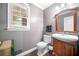 Stylish powder room featuring a wood vanity, gray walls, and a window that adds natural light at 2144 Lamplight Dr, Marietta, GA 30062