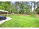 Expansive backyard with manicured lawn, trees, and an outbuilding, providing ample outdoor space at 5042 Southland Dr, Woodstock, GA 30188
