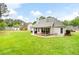 Expansive backyard features a manicured lawn, mature trees, and a charming covered patio for relaxation at 5042 Southland Dr, Woodstock, GA 30188