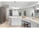 Well-lit bathroom with vanity, mirrors, a stool and travertine floors at 5042 Southland Dr, Woodstock, GA 30188