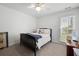 Cozy bedroom with neutral walls, a black bed frame, and natural light streaming through the window at 5042 Southland Dr, Woodstock, GA 30188