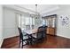 Formal dining room featuring hardwood floors, elegant lighting, and large windows at 5042 Southland Dr, Woodstock, GA 30188