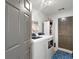 Practical laundry room with washer, dryer, and storage shelving at 5042 Southland Dr, Woodstock, GA 30188