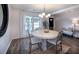 Formal dining room featuring a round table, modern chandelier and natural light from a window at 6030 Pattingham Dr, Roswell, GA 30075