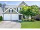 Charming two-story home with a two-car garage, beautiful green lawn, and mature landscaping at 6030 Pattingham Dr, Roswell, GA 30075