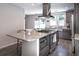 Kitchen featuring a granite island with gas cooktop, stainless steel hood, and gray cabinetry at 6030 Pattingham Dr, Roswell, GA 30075