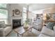 Open-concept living room featuring a fireplace, large windows, comfortable seating, and modern decor at 6030 Pattingham Dr, Roswell, GA 30075