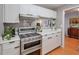 Kitchen featuring stainless steel stove and hood with white cabinets at 1418 Summit North Ne Dr # 1418, Atlanta, GA 30324