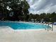 Community pool surrounded by trees and lounge chairs at 1418 Summit North Ne Dr # 1418, Atlanta, GA 30324