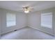 Large bedroom with neutral walls, carpet, ceiling fan, and natural light from two windows at 3342 Windpointe Ct, Buford, GA 30519
