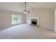 Cozy living room with a fireplace, a ceiling fan, and a large window for natural light at 3342 Windpointe Ct, Buford, GA 30519