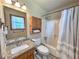 Well-lit bathroom featuring a granite vanity, wood cabinet, toilet and shower and tub combination at 3814 Lamar Way, Snellville, GA 30039