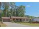 Ranch style home with a covered porch and large front yard lined with trees and green grass at 3814 Lamar Way, Snellville, GA 30039