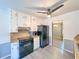 Eat-in kitchen featuring white cabinets, black appliances, modern gray flooring and a ceiling fan at 3814 Lamar Way, Snellville, GA 30039